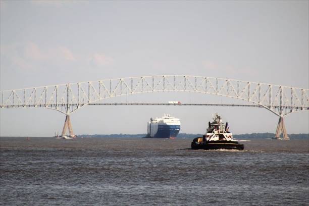 Small Tugboat and Large Automobile Cargo Ship