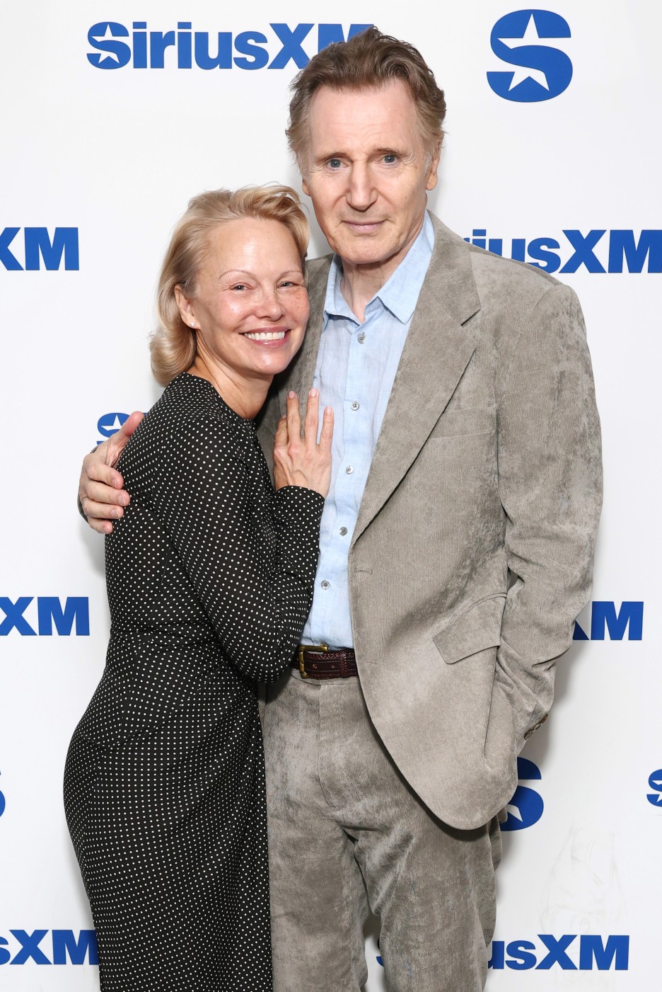Liam Neeson and Pamela ANderson hold hand sirius Naked Gun