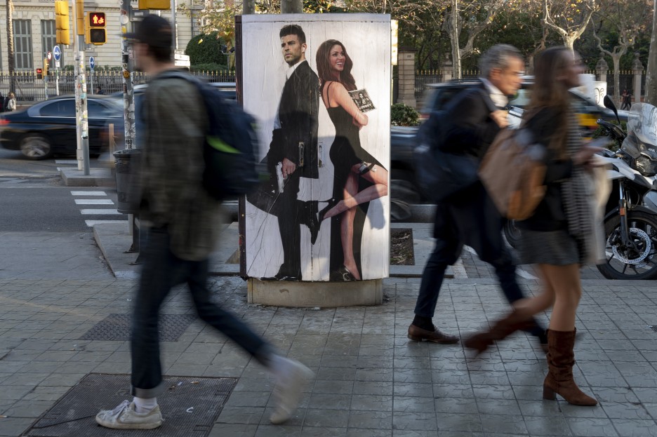 People walk past a mural depicting Gerard Piqué and Shakira